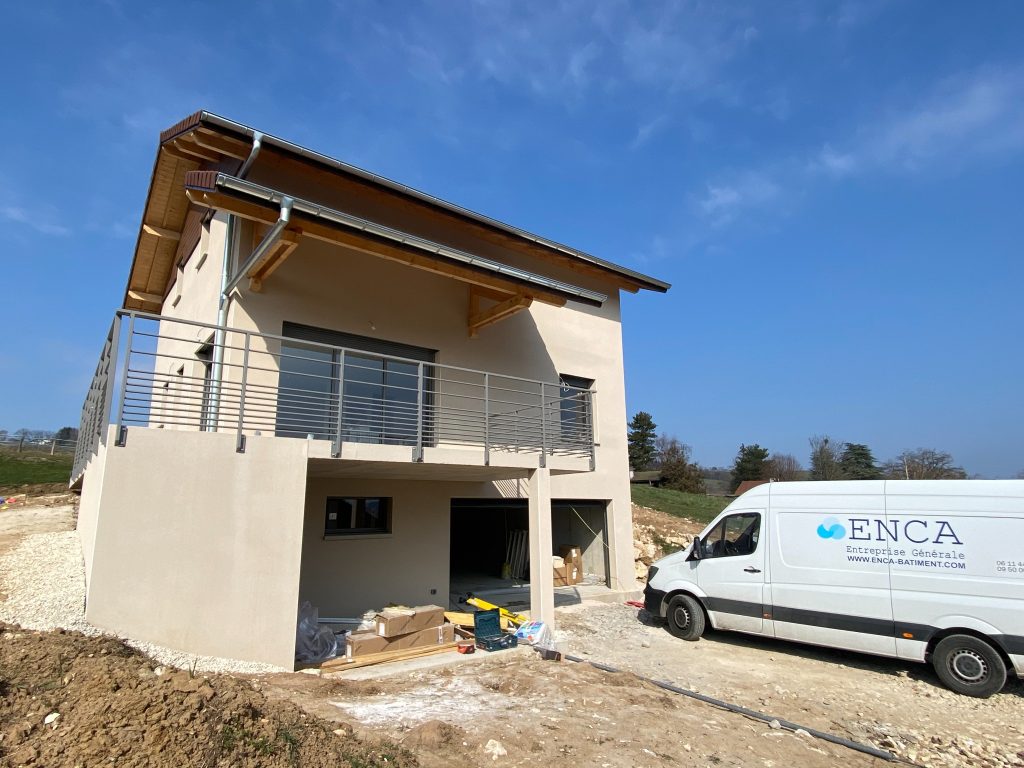 Maison individuelle aux finitions de façade achevées sur un chantier ENCA BTP en Haute-Savoie, utilitaire de l'entreprise au premier plan