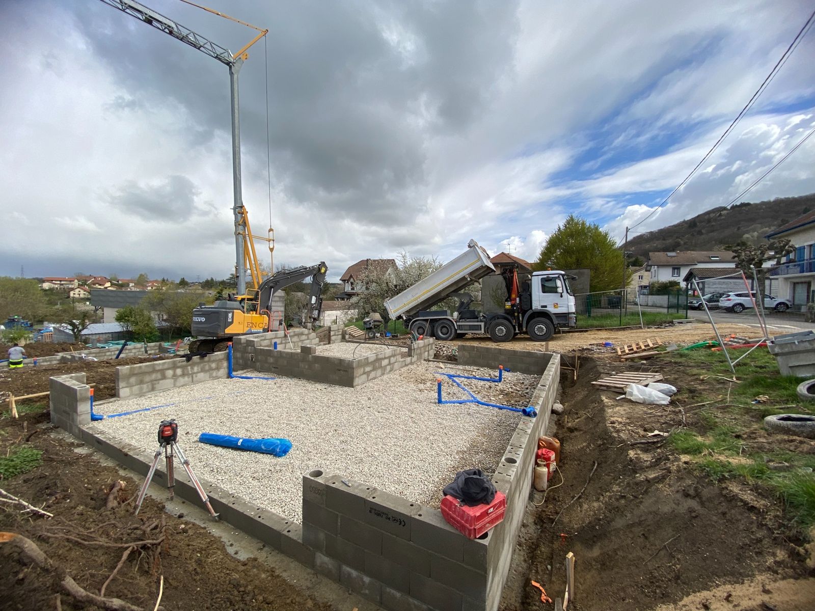 Camion benne et pelle ENCA BTP sur un chantier de maison à Saint-Cergues, avec grue à tour